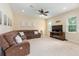 Cozy living room featuring a comfortable sofa, ceiling fan, and lots of natural light at 5024 Sw 114Th Street Rd, Ocala, FL 34476