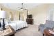 Main bedroom with a four-poster bed, sitting area, and tray ceilings at 5024 Sw 114Th Street Rd, Ocala, FL 34476