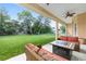 Comfortable outdoor seating area on the covered patio, overlooking the expansive green lawn at 5024 Sw 114Th Street Rd, Ocala, FL 34476