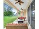 Relaxing covered patio with wicker furniture, ceiling fans, and views of the lush backyard at 5024 Sw 114Th Street Rd, Ocala, FL 34476