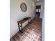 Bright hallway with wood floors featuring a console table and a view into the living room at 5235 Nw 33Rd Pl, Ocala, FL 34482