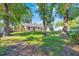 Spacious backyard with mature trees, a well-kept lawn, and a partial privacy fence, offering a serene outdoor space at 5581 Se 35Th St, Ocala, FL 34480