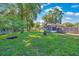 Lush backyard with a well-maintained lawn, mature trees, a fire pit, and a screened-in porch for relaxing outdoors at 5581 Se 35Th St, Ocala, FL 34480
