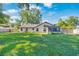 Lush backyard with a well-maintained lawn, mature trees, and a screened-in porch, perfect for outdoor living at 5581 Se 35Th St, Ocala, FL 34480