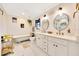 Charming bathroom featuring dual sinks, round mirrors, and a classic clawfoot bathtub, creating a relaxing and stylish space at 5581 Se 35Th St, Ocala, FL 34480
