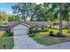 Beautiful home featuring a well-manicured lawn, mature trees, and an attached garage on a bright, sunny day at 5581 Se 35Th St, Ocala, FL 34480