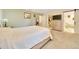 Bright main bedroom featuring a large bed, dresser with TV, and views into the ensuite bathroom and walk-in closet at 5581 Se 35Th St, Ocala, FL 34480