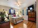 Bedroom with hardwood floors, ceiling fan, and colorful bedding at 5915 Se Holly Rd, Belleview, FL 34420