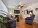 Cozy living room featuring hardwood floors, a fireplace, and an open layout to the kitchen at 5915 Se Holly Rd, Belleview, FL 34420