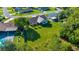 This aerial shot displays the house, surrounding green lawn, fenced yard, and pool at 6142 Se 37Th Ter, Ocala, FL 34480