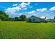 Extensive backyard showing vibrant lawn, home exterior, and a peaceful setting at 6142 Se 37Th Ter, Ocala, FL 34480