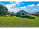 Expansive backyard showcasing lush green lawn and the home's rear elevation at 6142 Se 37Th Ter, Ocala, FL 34480