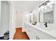 Bright bathroom featuring a double sink vanity, quartz counters, modern fixtures, and wood look flooring at 6142 Se 37Th Ter, Ocala, FL 34480