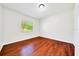 Bright bedroom featuring modern wood look flooring, neutral paint, and a window with natural light at 6142 Se 37Th Ter, Ocala, FL 34480