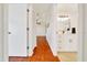 Bright hallway featuring wood floors leading to bathroom with white vanity and modern fixtures at 6142 Se 37Th Ter, Ocala, FL 34480