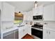 Bright kitchen with stainless steel appliances, white cabinets, and hardwood floors at 6142 Se 37Th Ter, Ocala, FL 34480