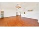 Spacious living room with hardwood floors, white walls and high ceilings with a ceiling fan at 6142 Se 37Th Ter, Ocala, FL 34480