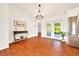 Well-lit living room with stylish hardwood floors, white walls and dining nook with doors to screened porch at 6142 Se 37Th Ter, Ocala, FL 34480