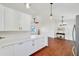 Open concept living area featuring wood floors, white cabinets, and modern lighting at 6142 Se 37Th Ter, Ocala, FL 34480