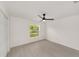 Bright bedroom features a modern ceiling fan, light gray flooring, and a window view of the property at 681 Sw Fig Tree Ln, Dunnellon, FL 34431