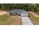 Beautiful single-story home featuring a manicured front lawn and a long driveway leading to a two-car garage at 681 Sw Fig Tree Ln, Dunnellon, FL 34431