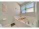 Modern bathroom features a large soaking tub with plant, and neutral decor at 7327 Sw 129Th Ln, Ocala, FL 34473