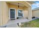 Covered front porch area with bench seating and a small garden, creating curb appeal at 7327 Sw 129Th Ln, Ocala, FL 34473