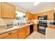 Well-lit kitchen with black appliances, wood cabinets, and an undermount sink at 7327 Sw 129Th Ln, Ocala, FL 34473