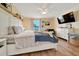 Bright main bedroom with ceiling fan, wood floors, lots of natural light, a TV, and a comfortable chair at 7327 Sw 129Th Ln, Ocala, FL 34473