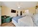 Bright main bedroom with ceiling fan, wood floors, an ensuite bathroom, and a comfortable green chair at 7327 Sw 129Th Ln, Ocala, FL 34473
