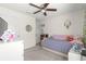 This cozy bedroom features neutral walls, carpet, a ceiling fan, and decor shelves at 8685 Sw 49Th Cir, Ocala, FL 34476