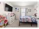 Inviting bedroom with a window, dresser, and mounted TV at 8685 Sw 49Th Cir, Ocala, FL 34476