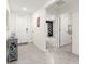 Hallway showing light gray tile flooring with an open layout, white walls and doors, and wall decorations at 8685 Sw 49Th Cir, Ocala, FL 34476