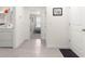 Hallway showing gray tile flooring with the laundry machines and the entrance to a bedroom at 8685 Sw 49Th Cir, Ocala, FL 34476