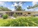 Well-maintained backyard with green grass, lush landscaping, and a screened patio at 9085 Sw 96Th Ln # B, Ocala, FL 34481