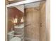 Walk-in shower with glass doors, tile surround, grab bar and handheld shower fixture at 9085 Sw 96Th Ln # B, Ocala, FL 34481
