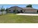 Backyard view of the home with a well-maintained lawn and a white fence at 9923 Se 64Th Ave, Belleview, FL 34420