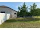 Backyard view with a white fence, young trees, and a screened-in pool area at 9923 Se 64Th Ave, Belleview, FL 34420