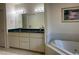 Bright bathroom featuring double sinks, a large mirror, and a soaking tub at 9923 Se 64Th Ave, Belleview, FL 34420