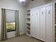 Bedroom features built-in shelving and closet unit with window offering natural light at 9923 Se 64Th Ave, Belleview, FL 34420
