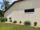 Side exterior of the home with a small window and landscaping at 9923 Se 64Th Ave, Belleview, FL 34420