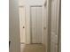 Hallway with multiple doors and neutral carpet flooring at 9923 Se 64Th Ave, Belleview, FL 34420