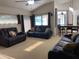 Comfortable living room with ceiling fan, black recliners, and view to kitchen, dining, and outdoor spaces at 9923 Se 64Th Ave, Belleview, FL 34420
