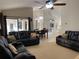 Comfortable living room with ceiling fan, black recliners, and view to kitchen, dining, and outdoor spaces at 9923 Se 64Th Ave, Belleview, FL 34420