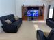 Comfortable living room featuring plush black reclining seating and an entertainment center at 9923 Se 64Th Ave, Belleview, FL 34420