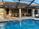 A view of the pool and screened lanai area, with outdoor dining and lounge furniture at 9923 Se 64Th Ave, Belleview, FL 34420