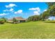 Wide backyard with mature trees and manicured lawns and the back of the home at 9925 Sw 95Th Loop, Ocala, FL 34481