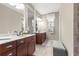 Dual sink bathroom with dark wood cabinets, neutral paint, and decorative stool at 9925 Sw 95Th Loop, Ocala, FL 34481