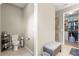 Bathroom with toilet, tiled flooring, and a bench; a walk-in closet is visible at 9925 Sw 95Th Loop, Ocala, FL 34481