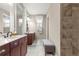 Bright bathroom featuring dual vanities, a tiled shower, and a comfortable bench at 9925 Sw 95Th Loop, Ocala, FL 34481
